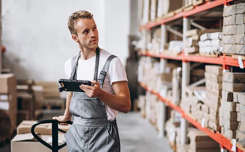 an warehouse employee inspecting inventory items with a tablet