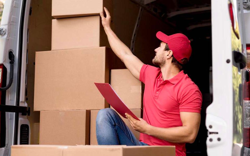 Man organizing inventory in a storage area, representing efficient SKU rationalization for e-commerce businesses.